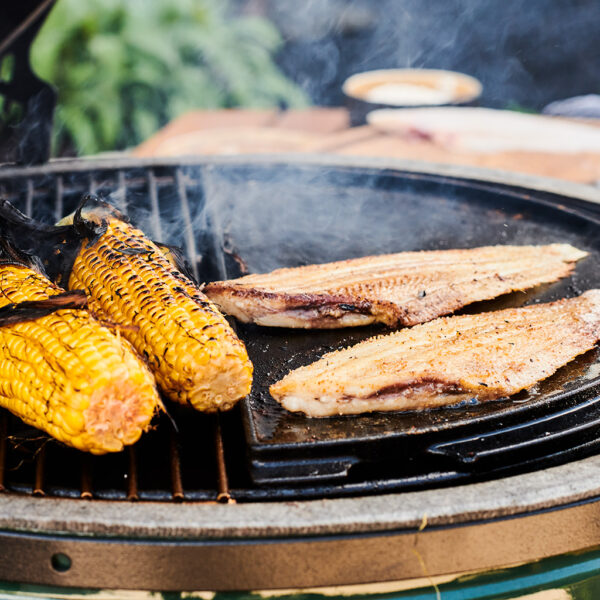 Fischfilets und Maiskolben auf der Grillplatte